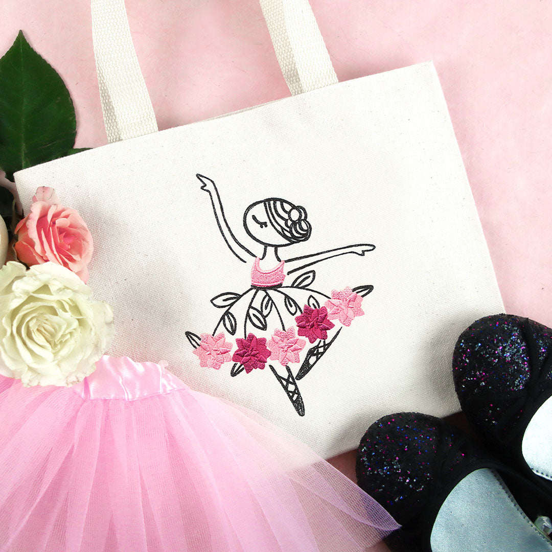 Embroidered ballerinas in tutus with pink flowers, roses, and black glitter shoes on a canvas bag.