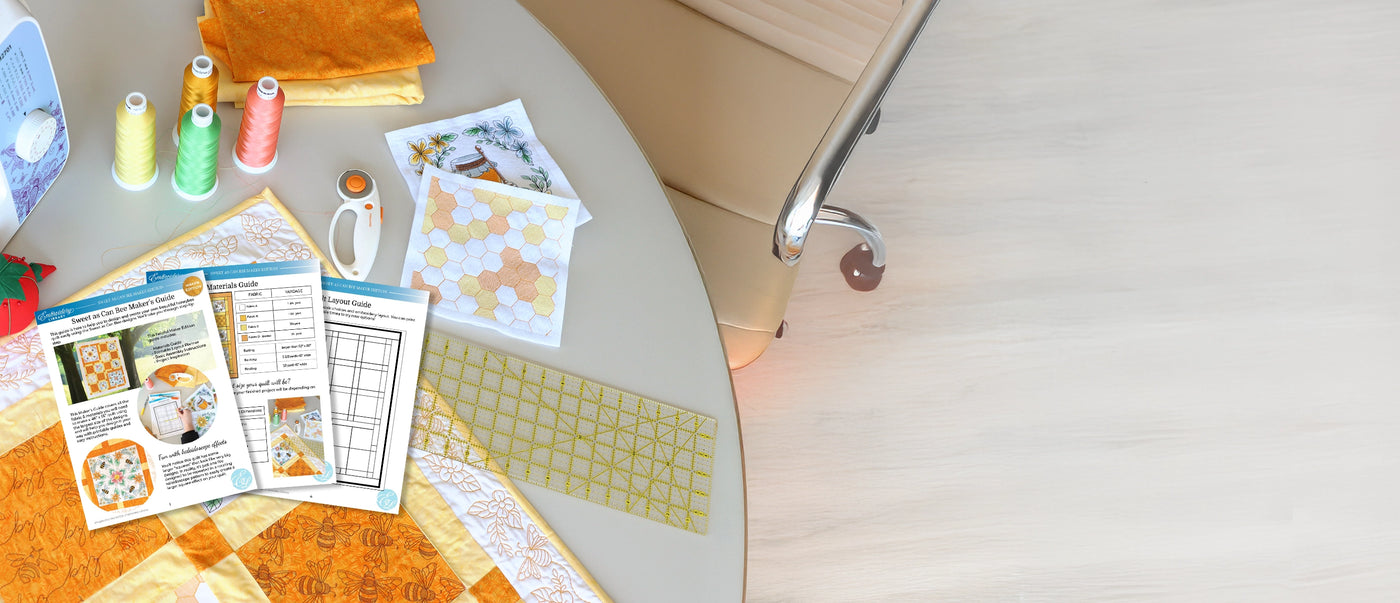 Quilting materials and tools on a table with an embroidery machine.