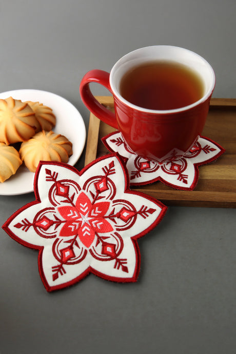 Machine embroidery Nordic snowflake coaster surrounded by cookies and tea