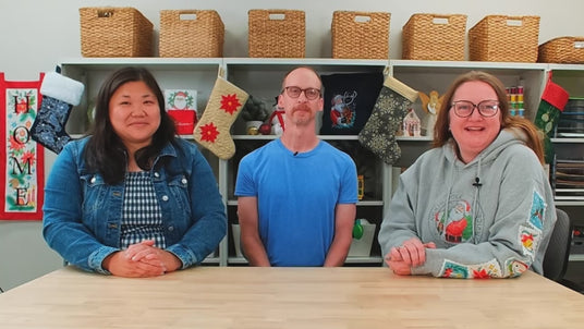 Video of three people sitting in a craft room talking.