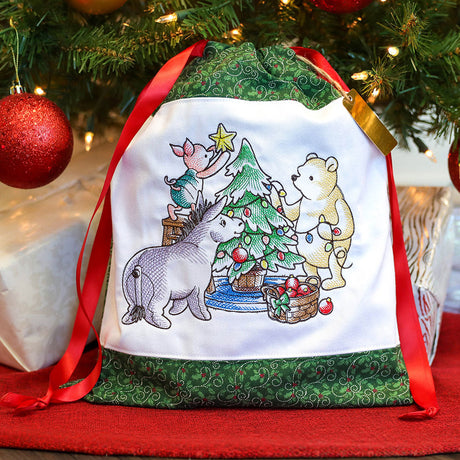 A drawstring toy bag featuring a machine embroidery design of a Christmas themed Pooh scene.