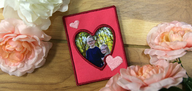 Completed embroidered Hearts Abound Photo Frame project, featuring a portrait of brother and sister  with flowers surrounding the frame