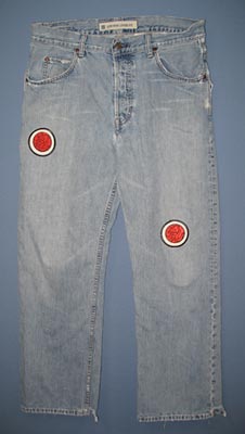 A pair of faded jeans with embroidered patches sewn on