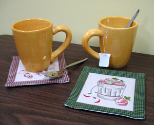 Two mugs of tea sitting on embroidered Quilted Coasters, featuring A Autumn Abundance (Vintage) designs
