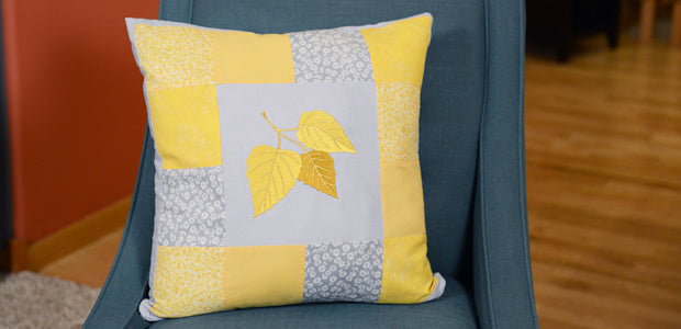 Completed patchwork pillow project, featuring Birch Leaf Trio design in yellow