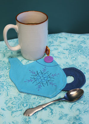 Tea setting with completed Teapot Mug Rug, featuring Star Snowflake (Redwork) design