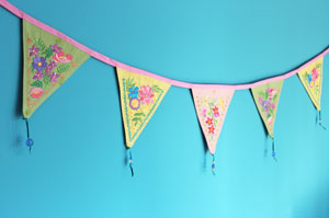 Embroidered triangles hanging on a wall, featuring Springtime Bunting designs