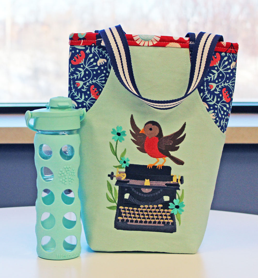 Completed embroidered pocket tote with bird and typewriter design