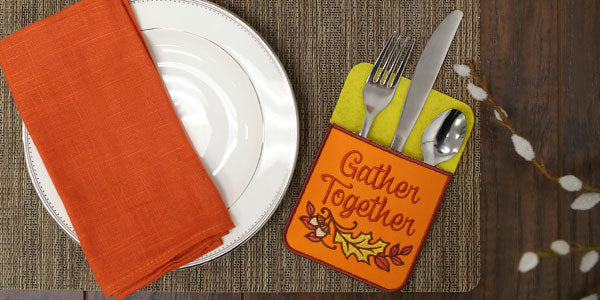 Place setting featuring embroidered Silverware Pockets reading 'Gather Together'