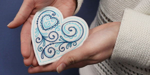 A pair of hands holding the completed Hand Warmer