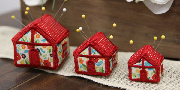 Completed pincushions in three sizes, featuring House design