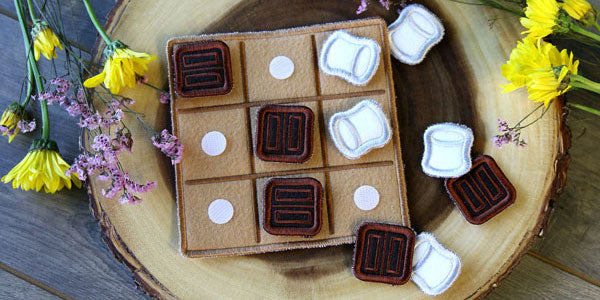 Completed S'Mores Tic-Tac-Toe project, dandelions in the background