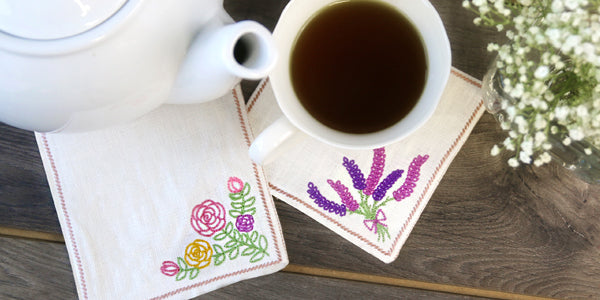 Place setting with teapot and mug, featuring completed Stitch and Turn Coasters
