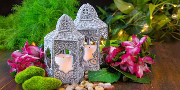 Completed 3D Enchanting Lantern project with candles, surrounded by flowers and stones