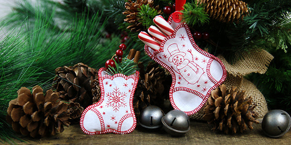 Completed embroidered Heirloom Stockings holding candy canes