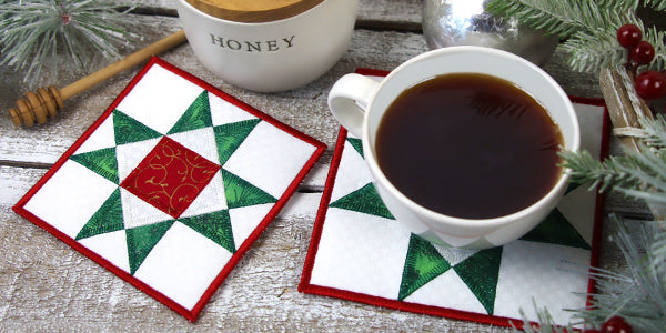 A place setting with a cup of coffee or tea, a honey  jar, and completed Layered Applique Trivet designs