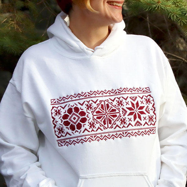 White sweatshirt featuring a machine embroidery design of a Nordic motif