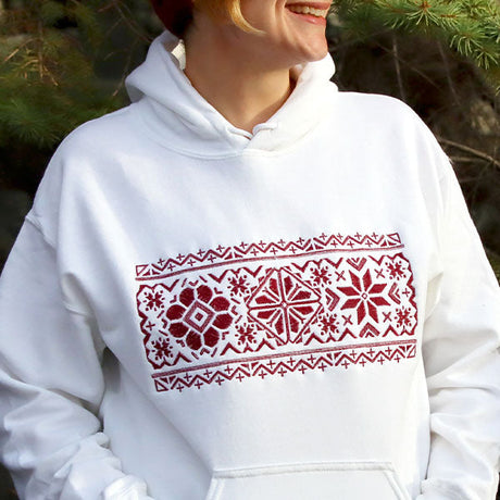 White sweatshirt featuring a machine embroidery design of a Nordic motif