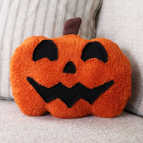 a pumpkin Halloween pillow featuring a machine embroidered applique jack-o-lantern face