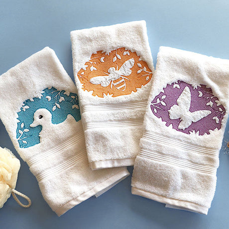 Embossed machine embroidery designs on three bath towels.