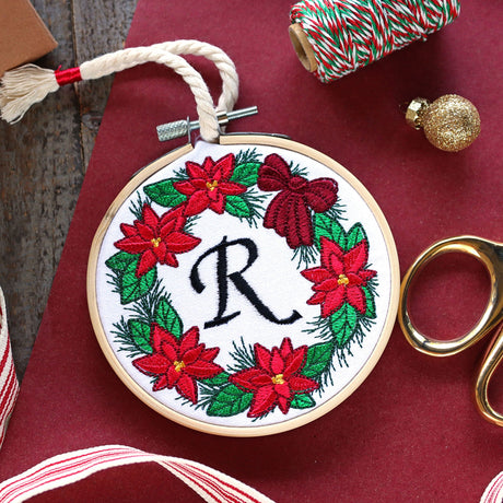poinsettia wreath machine embroidery design in a hand embroidery hoop