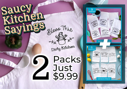 Kitchen-themed aprons and tea towels with humorous machine embroidery sayings on a table with vegetables and kitchen items. Promotional text 'Saucy kitchen sayings 2 packs just $9.99'
