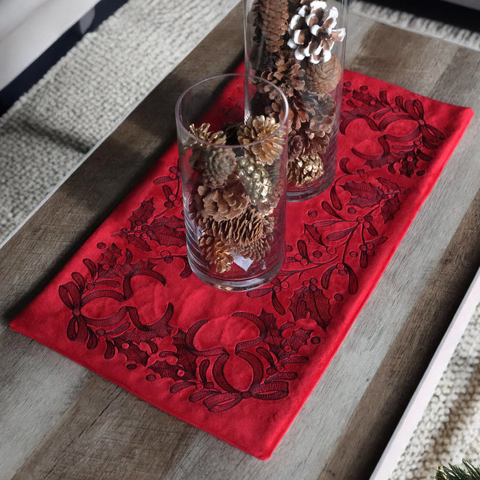 Machine embroidery Christmas floral design on red table center with vases on top.