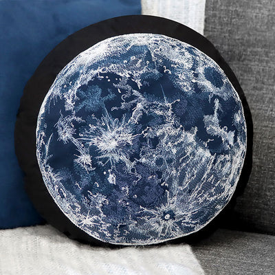Round pillow with machine embroidery moon design on a gray couch