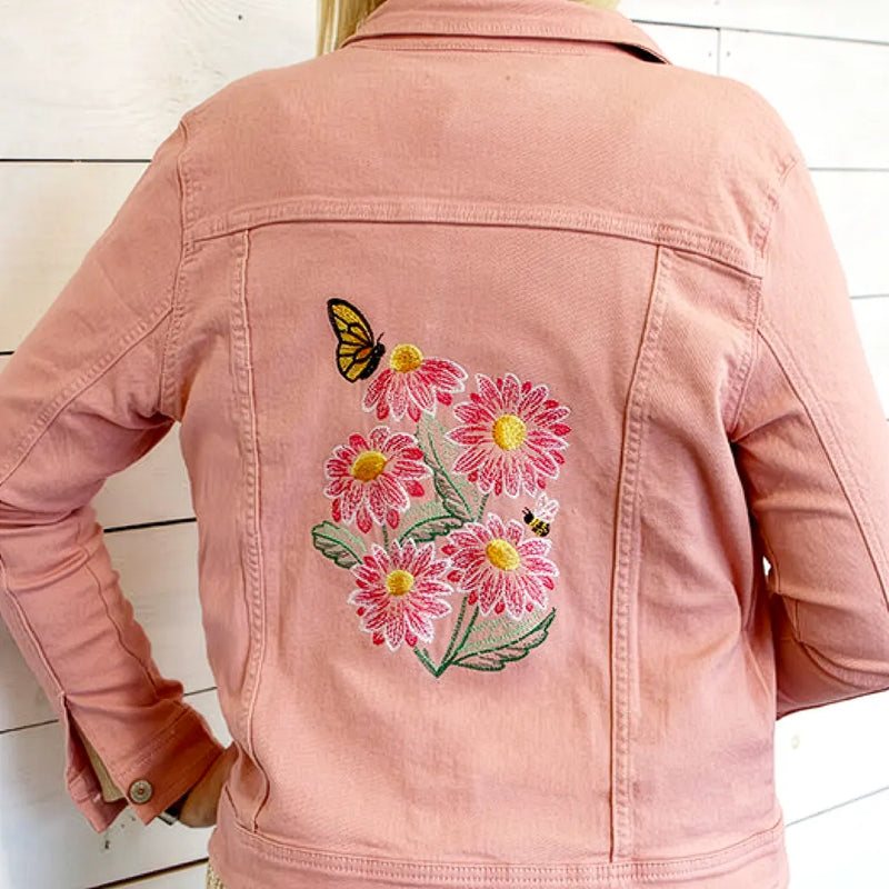 Pink jacket with floral daisy and butterfly machine embroidery on a white background