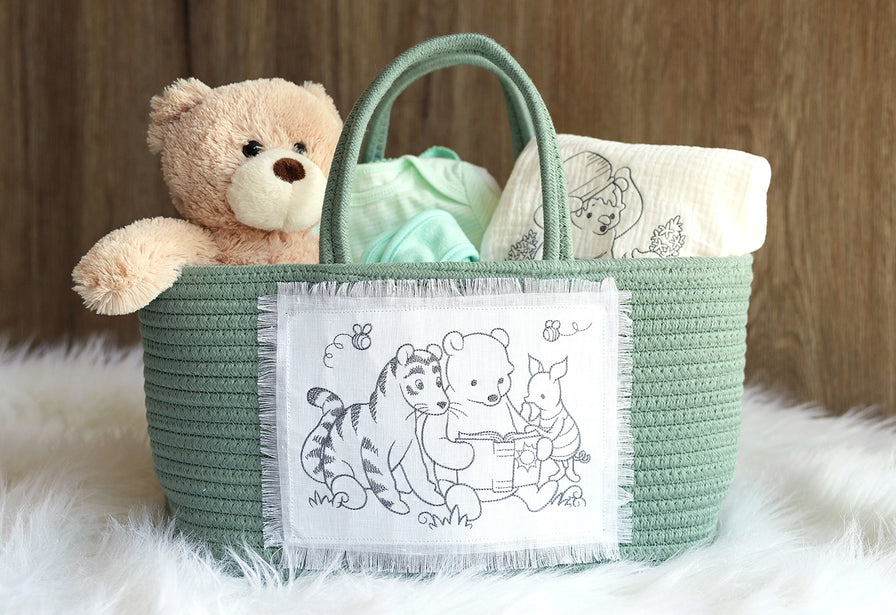Machine embroidery pooh and friends designs on rope basket and baby blanket in a gift setting.