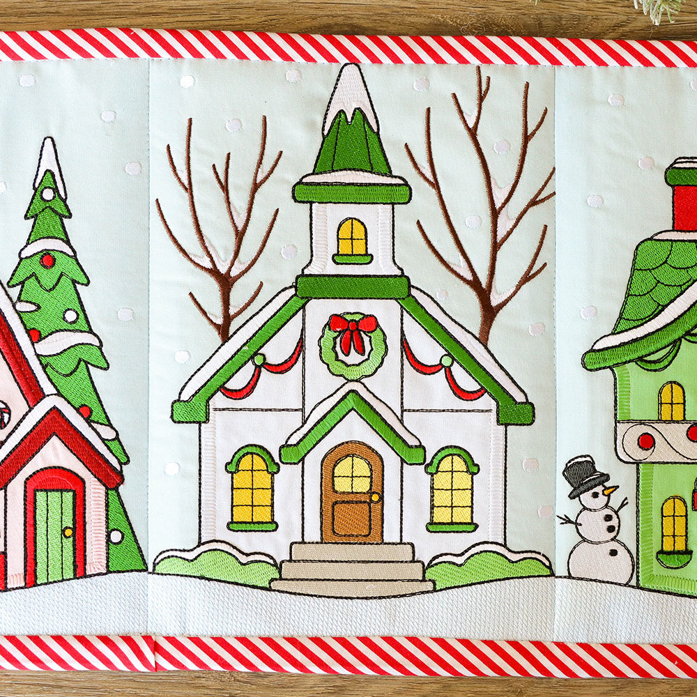 Digitally downloadable machine embroidery design of a church with wreath, snowman, and trees on a striped winter border.