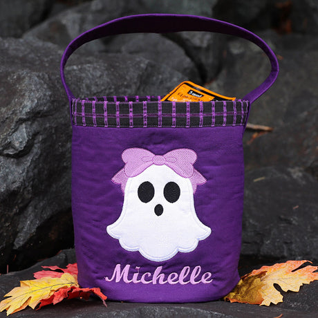 Embroidered ghost with bow, name, and autumn leaves on a purple bag; digitally downloadable machine embroidery Design Pack.