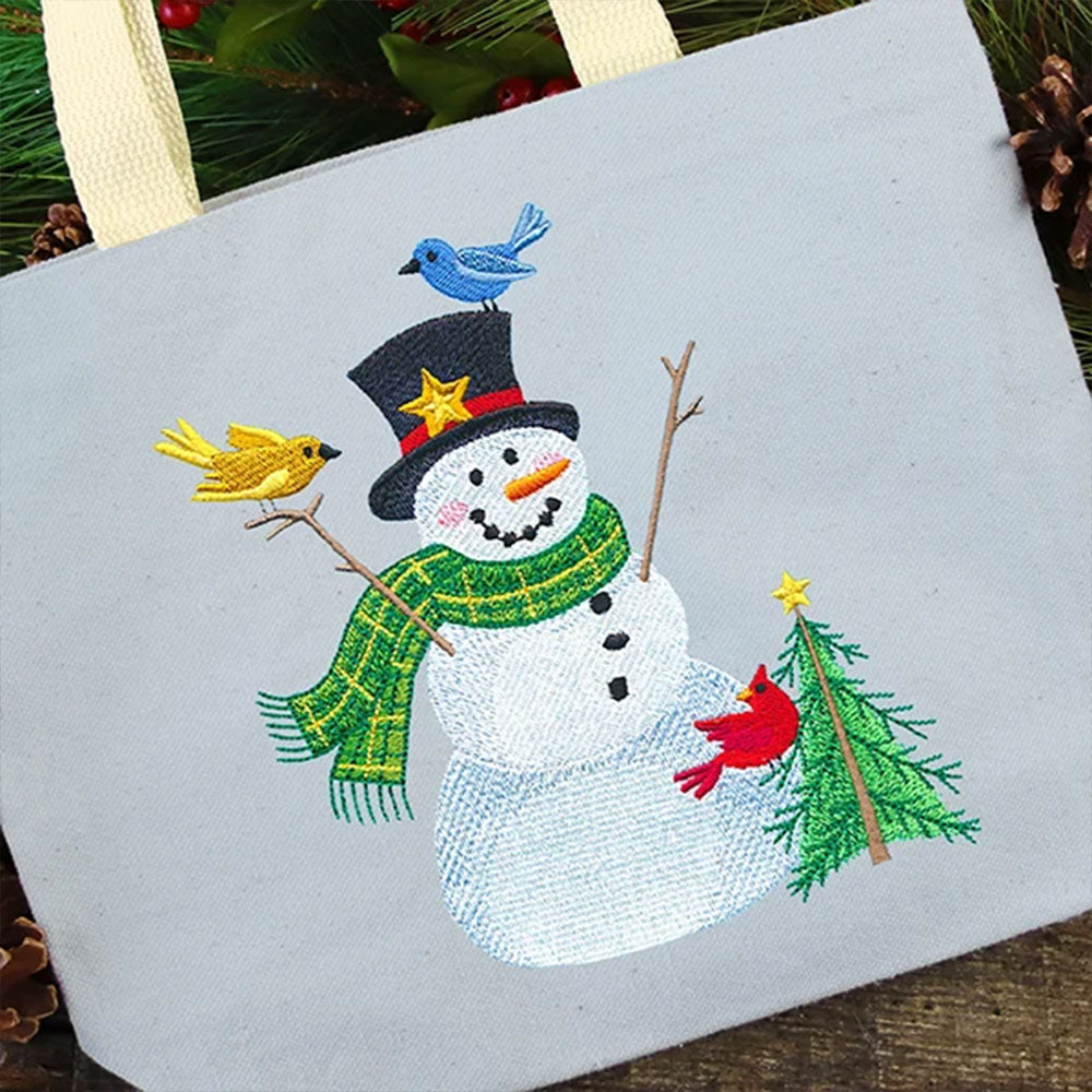 Digitally downloadable machine embroidery design of a smiling snowman with a black top hat, green scarf, three birds, and a decorated Christmas tree.