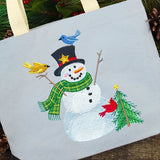 Digitally downloadable machine embroidery design of a smiling snowman with a black top hat, green scarf, three birds, and a decorated Christmas tree.