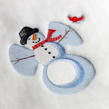 Digitally downloadable machine embroidery design of a snowman with a black hat, red scarf, stick arms, and a small red bird above its wing.