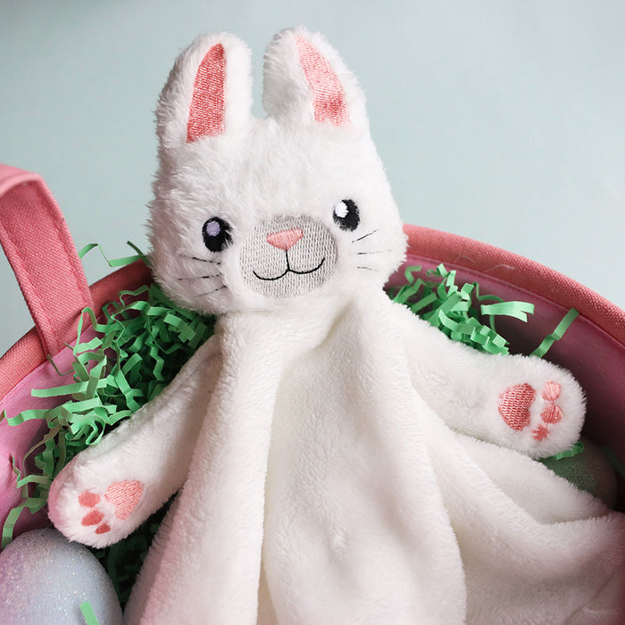 White machine embroidery bunny blankie with pink accents in a pink basket with green grass