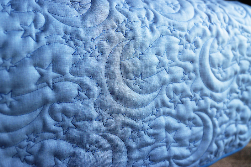 Celestial machine embroidery edge-to-edge design on blue fabric