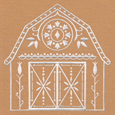 White embroidered symmetrical barn design with double doors, floral accents, and decorative circular pattern on a brown fabric background.