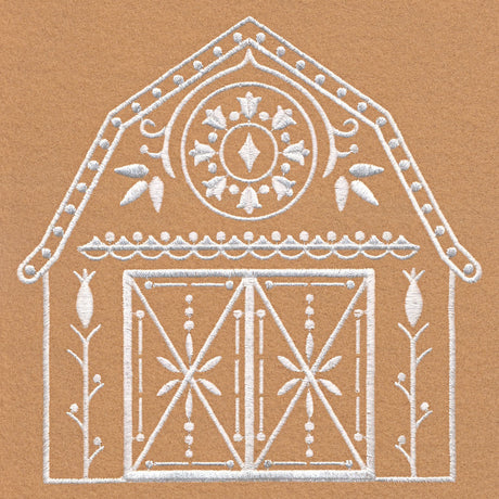 White embroidery of a barn with decorative floral and geometric patterns embroidered on a brown fabric background, showing detailed stitching of doors and roof.
