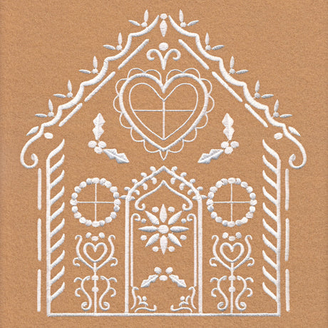 White embroidery on tan fabric depicts a symmetrical house shape with heart, floral motifs, circular windows, and decorative trim along the roof edges.