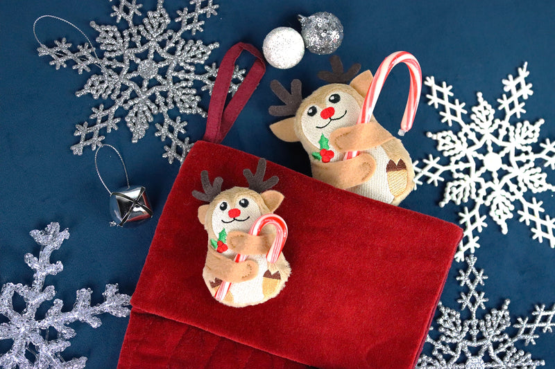 Two machine embroidery reindeer candy huggers holding candy canes on a stocking