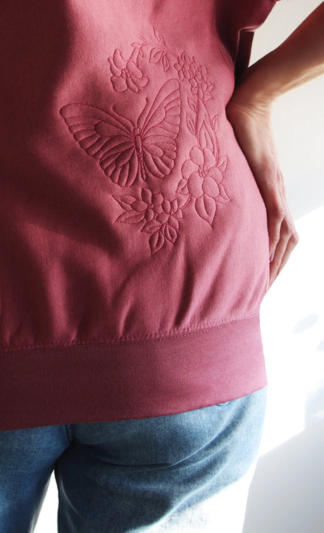 Machine embroidery butterfly and flower design on a pick sweatshirt